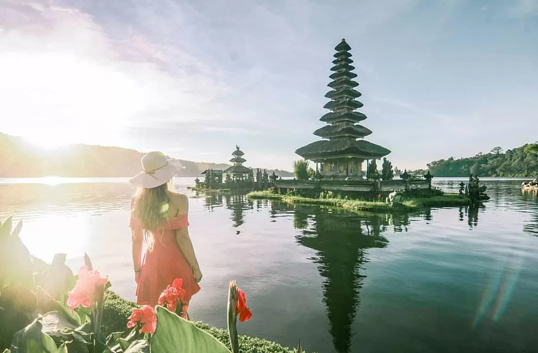 Wisatawan menikmati keindahan pura di tepi danau saat tour harian Bali.
